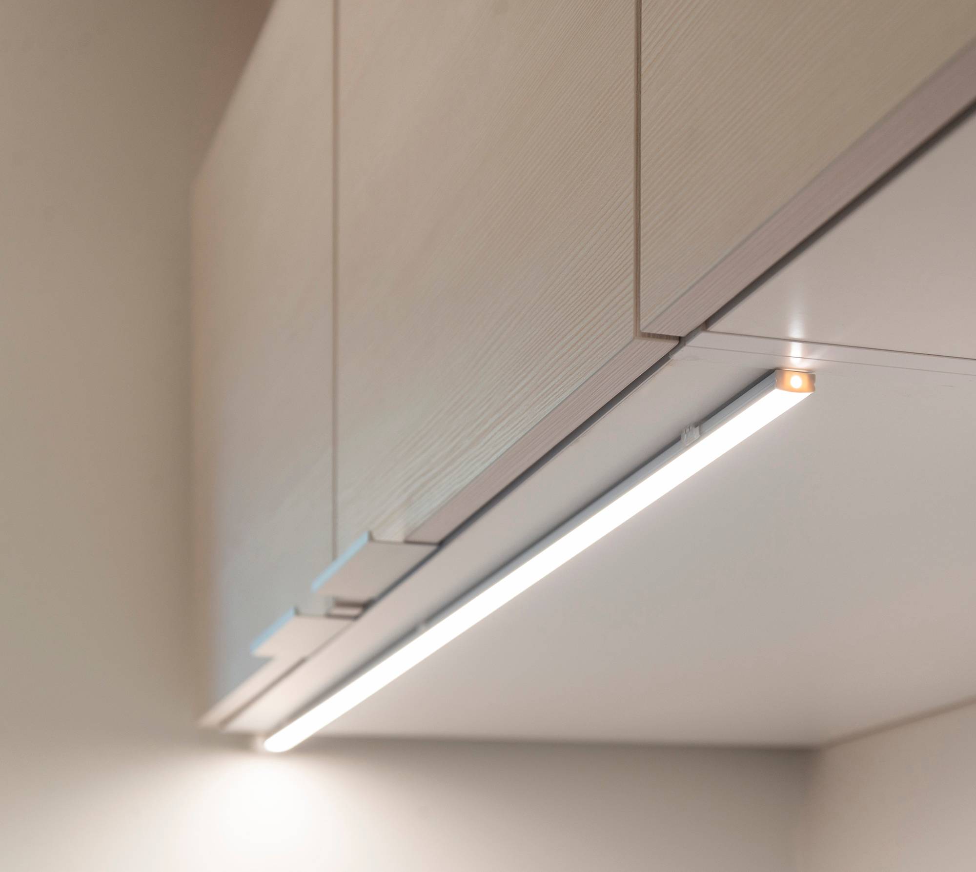 An der Vorderkante eines Schranks montiertes LED-Profil, das in die Arbeitsplatte eingelassen ist. Ledstore.fi