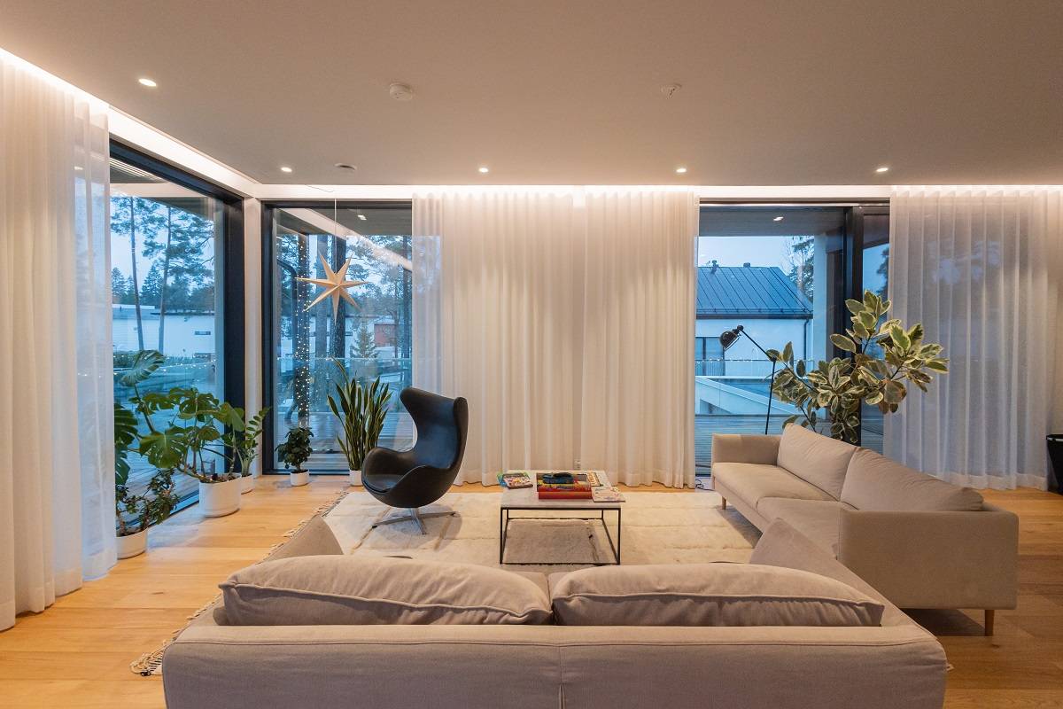 Referenzprojekte Das Wohnzimmer des Hauses Eteläaho ist mit LED-Streifen und LED-Spots an den Rändern des Raumes ausgestattet.