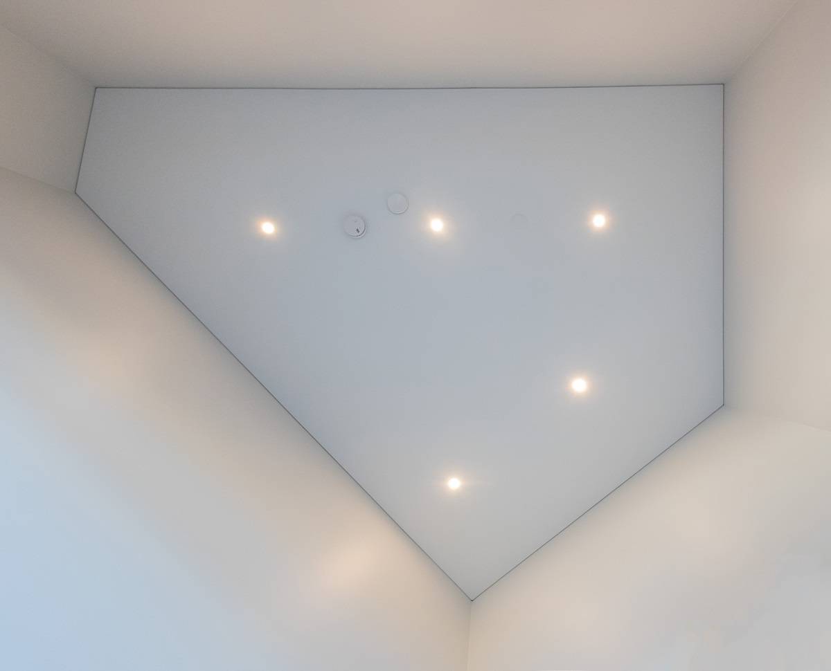 Led-Spots an der Decke, direkt von unten gesehen. Die Anordnung der Strahler kann an die Form des Raumes angepasst werden, wie in diesem fünfeckigen Raum.