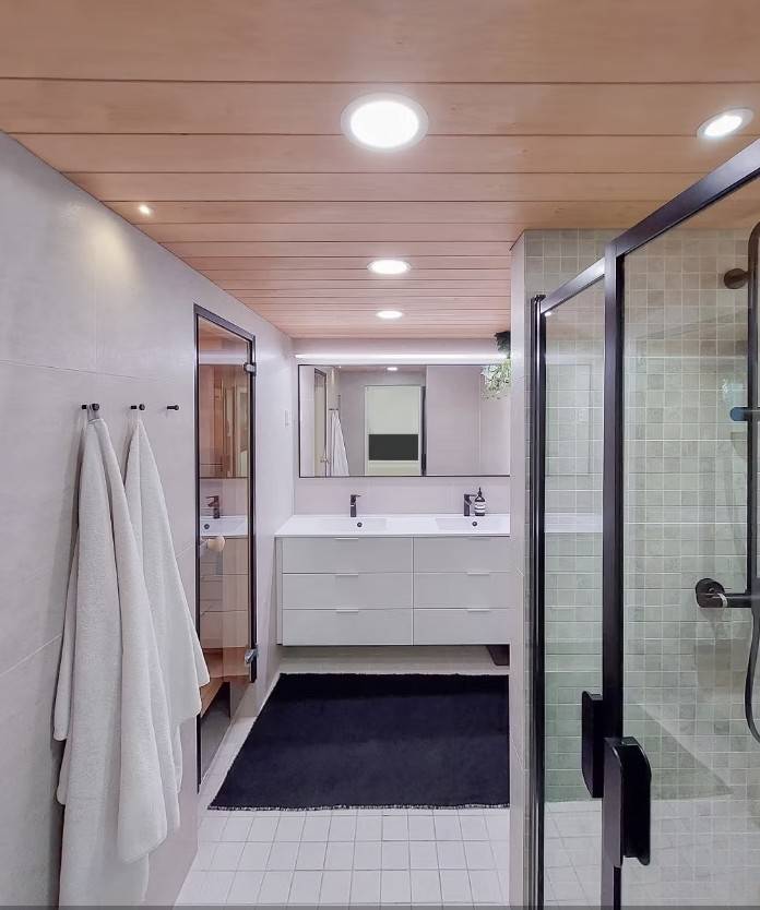 Badezimmerbeleuchtung mit Paneelleuchten, Spots, LED-Schienenleuchten vor dem Spiegel und wasserdichte Spots über dem Waschbecken.