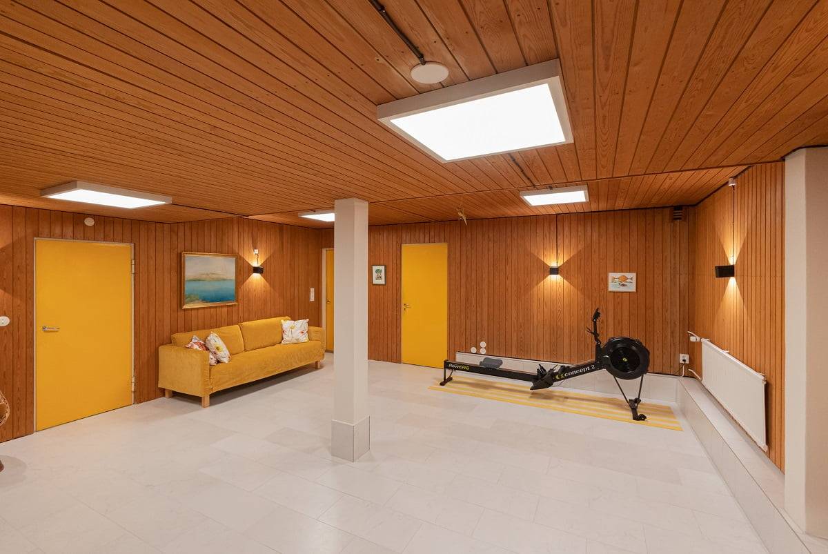 Gutes Licht ist gut für das Training. Panel 600 ist in der Farbtemperatur einstellbar von kaltweiß bis warmweiß. An der Wand Funk, schwarze Wandleuchten. LedStore.fi