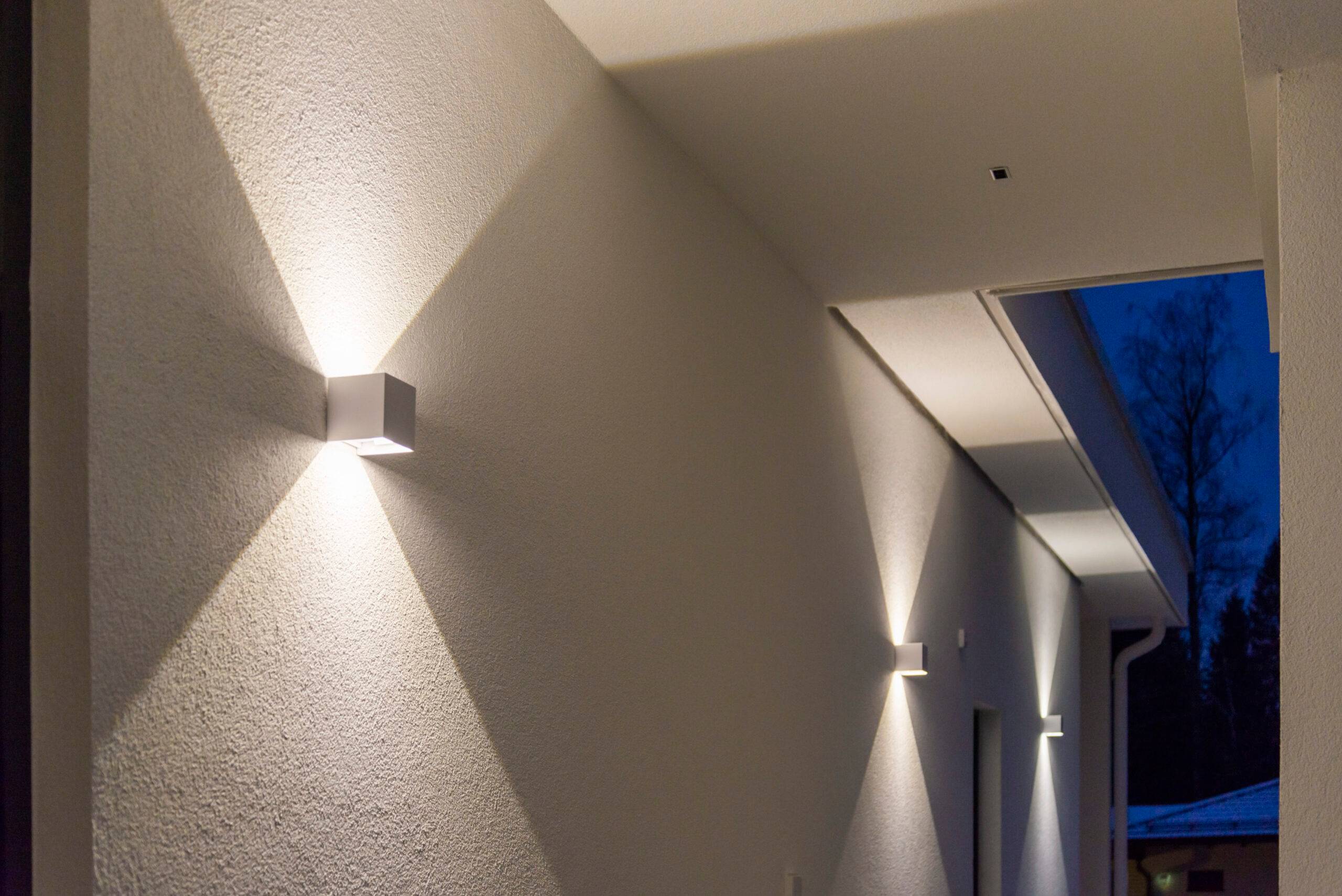 Die kubischen weißen LED-Wandleuchten leuchten sowohl nach oben als auch nach unten und erzeugen so ein scharfes Lichtmuster an der Wand.