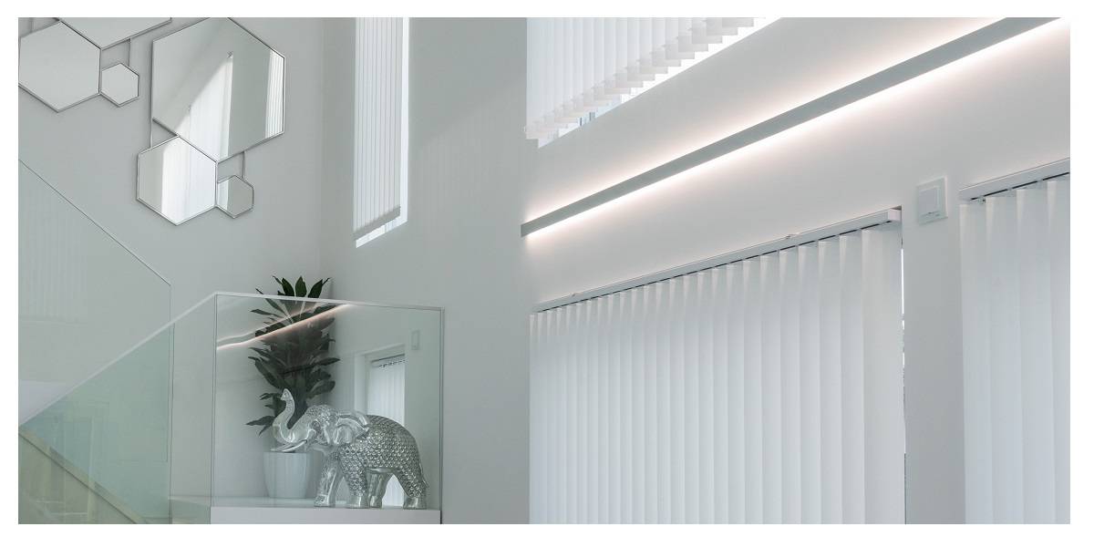 Lichtband in einem Aluminiumprofil für indirekte Beleuchtung zwischen den Fenstern eines Wohnzimmers - Lichtdesign im Wohnzimmer