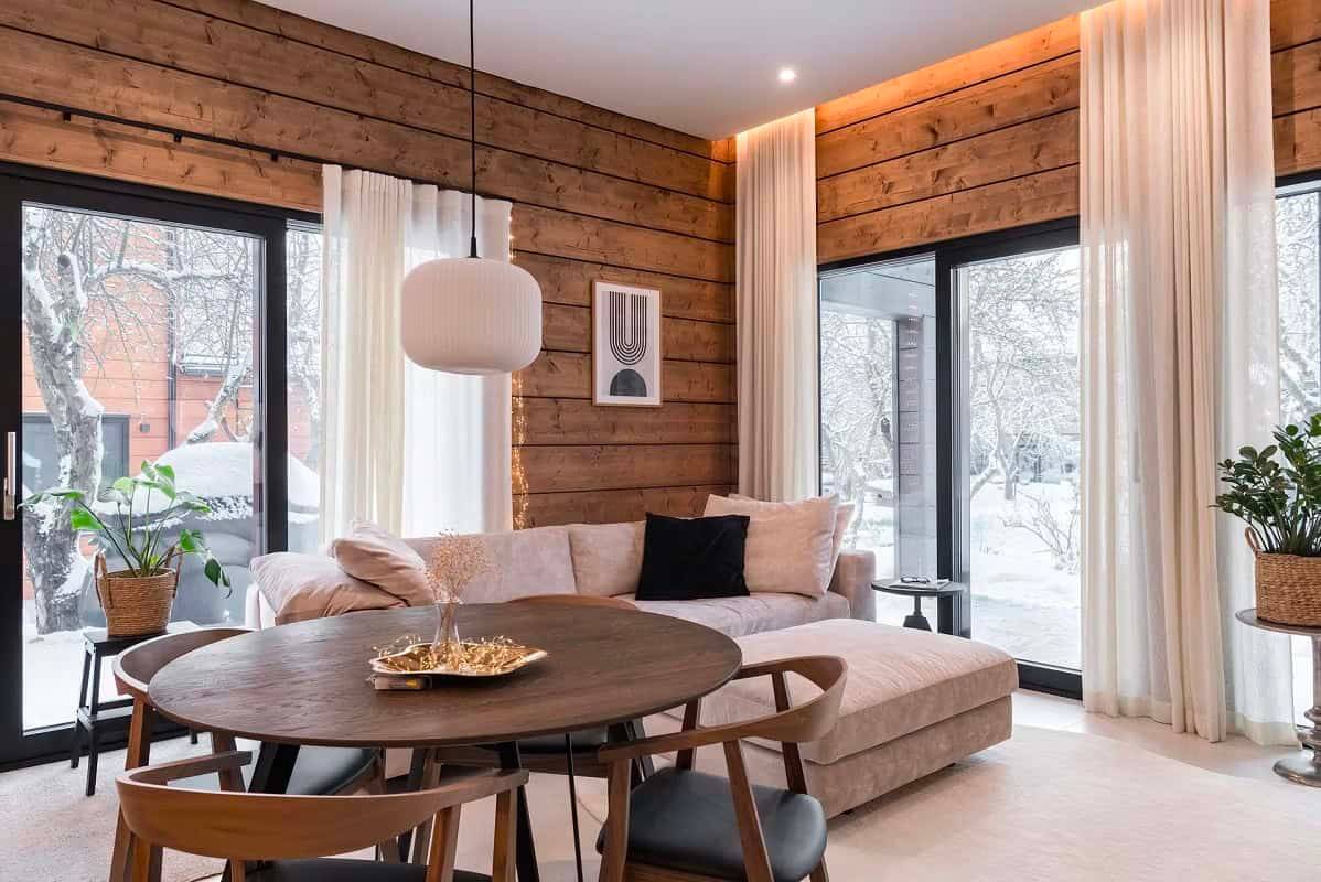 Ein modernes und warmes Wohnzimmer mit LedStore.fi LED-Downlights, die die Holzoberflächen und die Architektur des Raumes hervorheben.