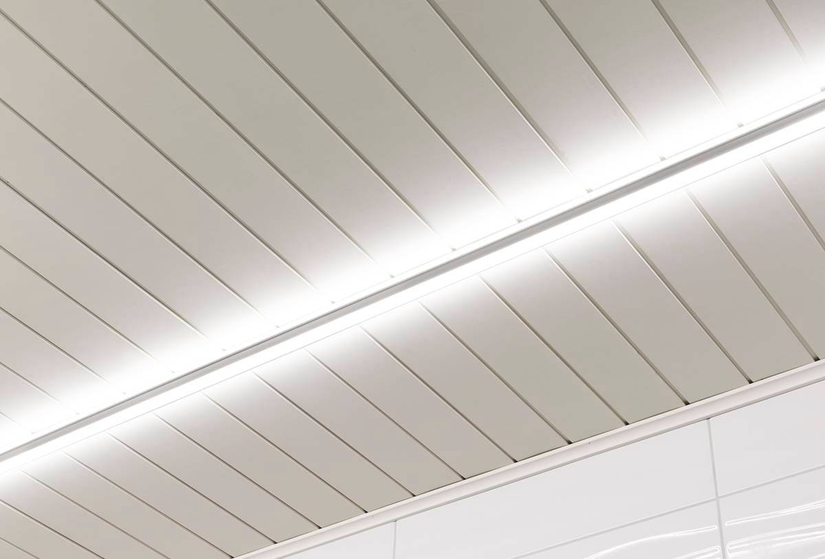 LedStore.fi bietet moderne Deckenleuchten an, die durch eine zentrale LED-Leiste zum Leben erweckt werden. Die glatte Oberfläche der rechteckigen Paneele passt perfekt zu der sauberen und minimalistischen Ästhetik des Raumes.