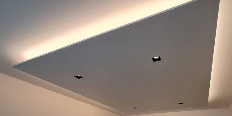 Eine moderne Deckenlösung mit einer eingelassenen rechteckigen Platte mit vier quadratischen LED-Leuchten. Die Kanten des Paneels leuchten sanft und erzeugen ein subtiles Licht an der Decke und den Wänden für einen modernen Look. Diesen Stil finden Sie in der großen Auswahl an LED-Beleuchtung von LedStore.fi.