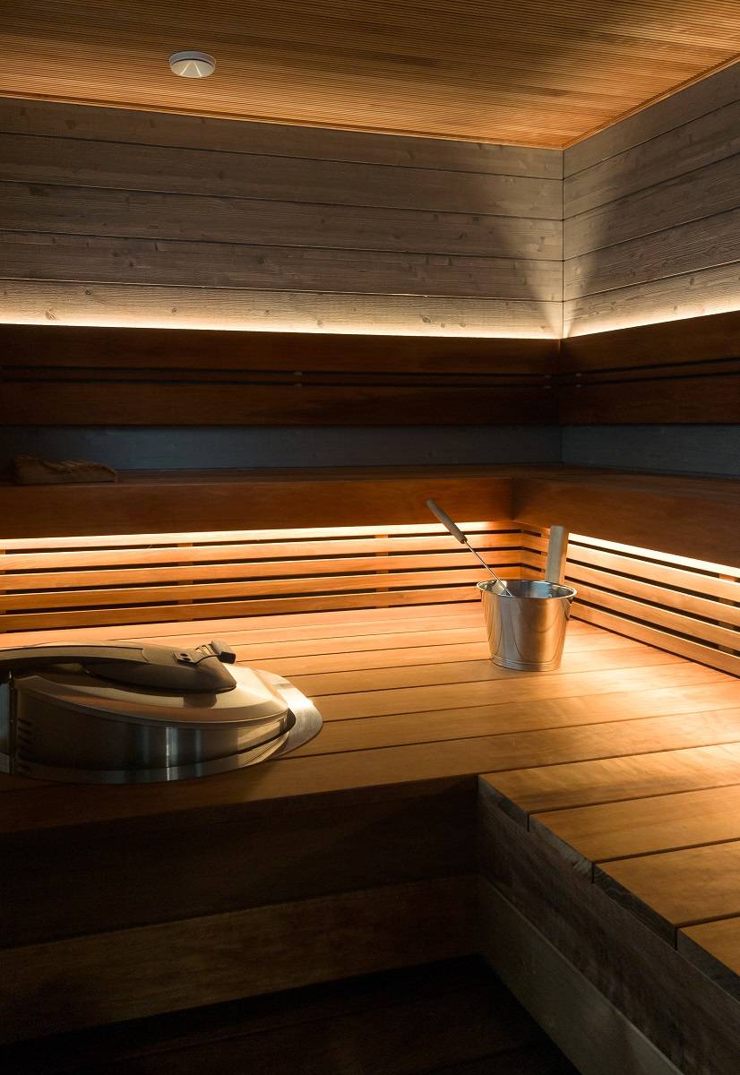 In der Sauna wurde hinter der Rückenlehne ein LED-Streifen angebracht, der nach oben strahlt, sowie unter den Sitzbänken, der nach unten strahlt.