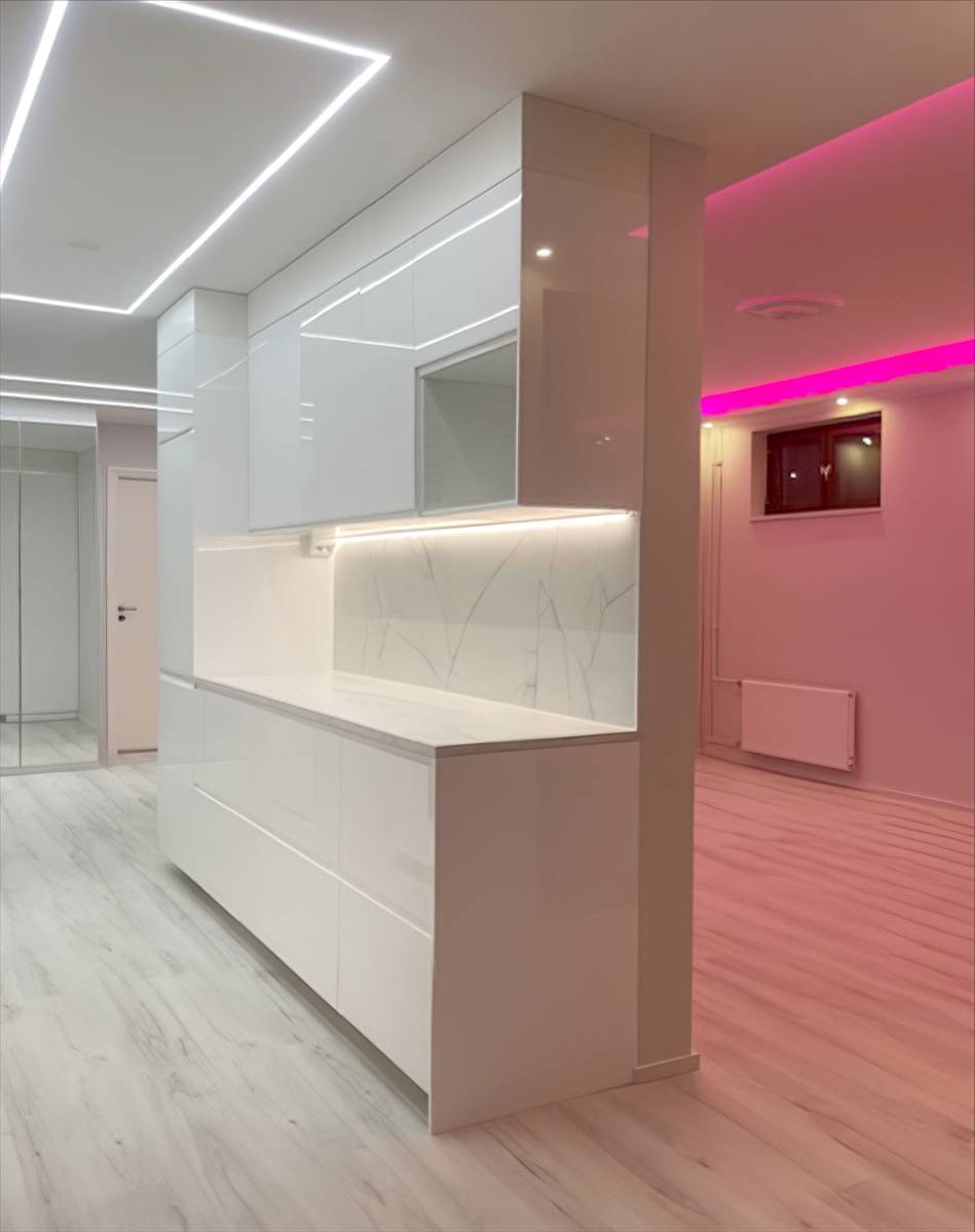 Quadratische Lichtlinie an der Küchendecke und rosa LED-Licht im Wohnzimmer.